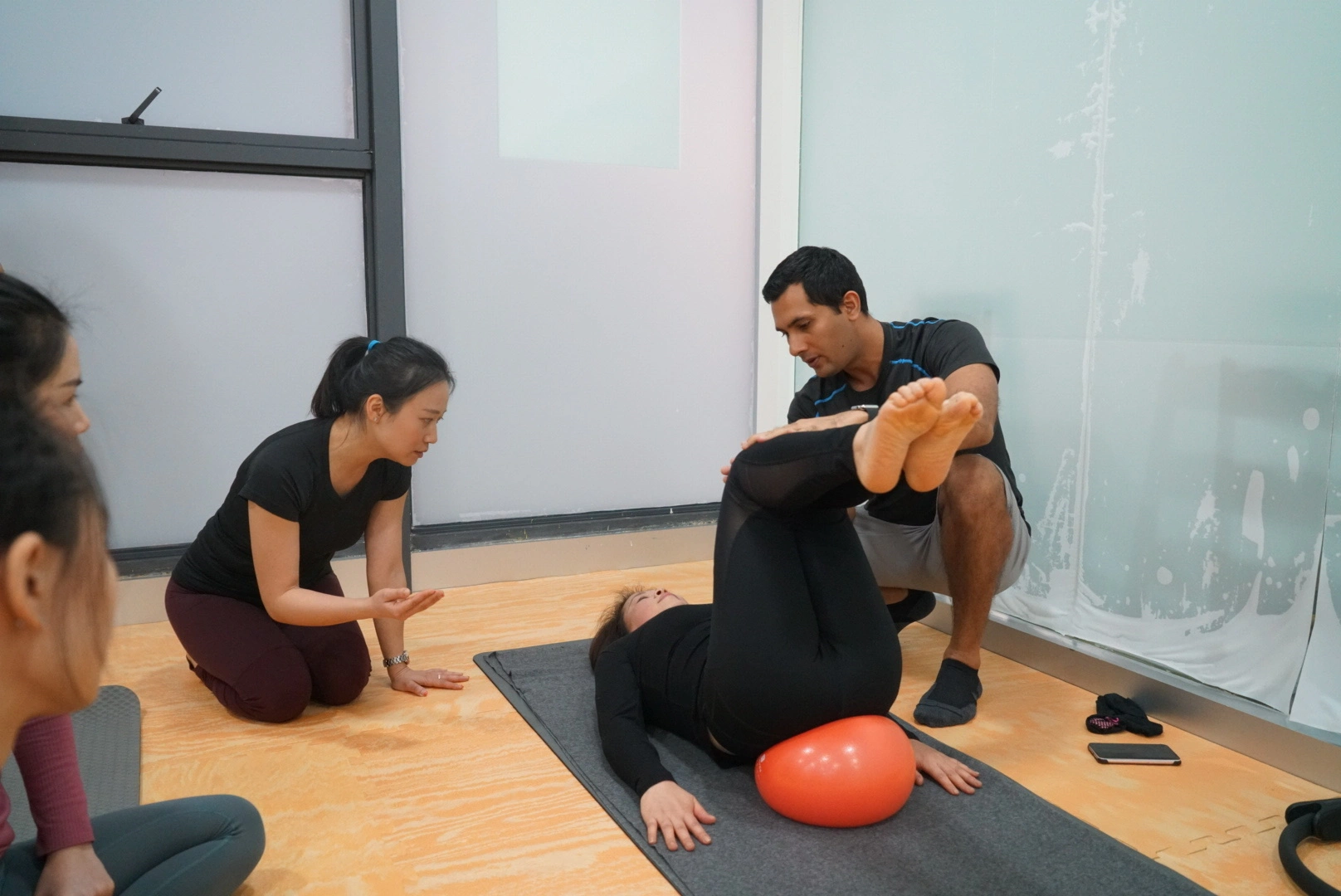 Pilates therapist helping a female client perform reformer Pilates exercises in a bright modern studio Pilates therapist helping a female client perform reformer Pilates exercises in a bright modern studio